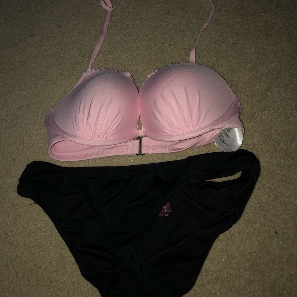 Pink bikini top and black bikini bottoms